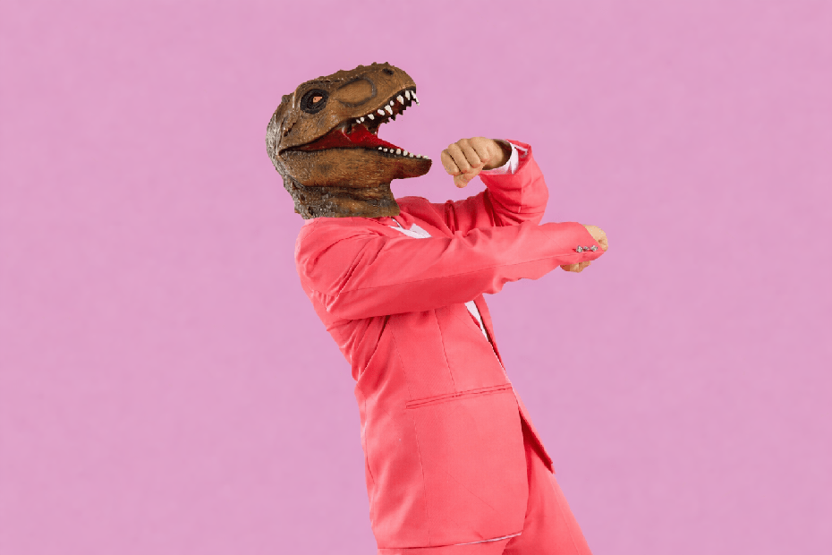 Personne en costume rose et masque de dinosaure dans une pose dynamique