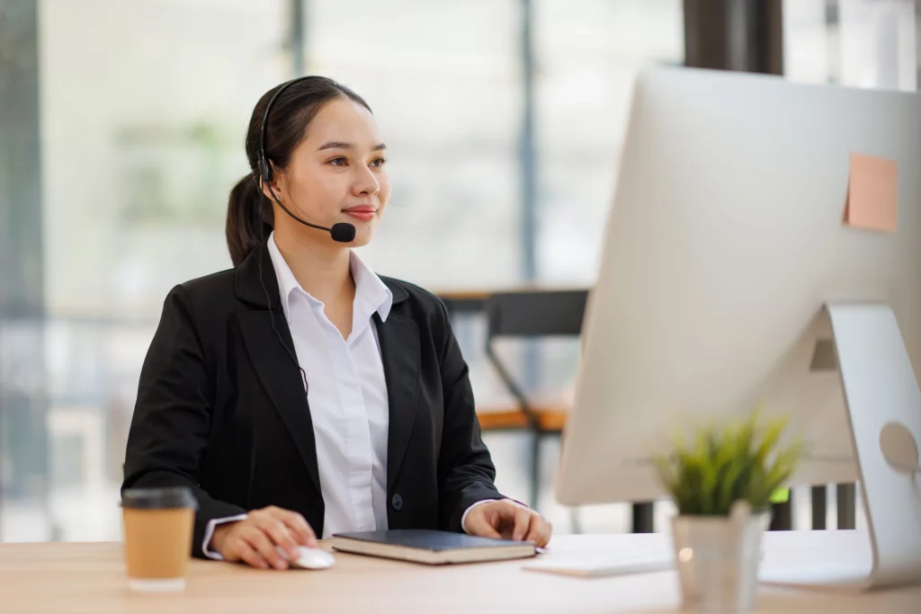 Hôtesse avec casque téléphonique assurant un support administratif à son bureau
