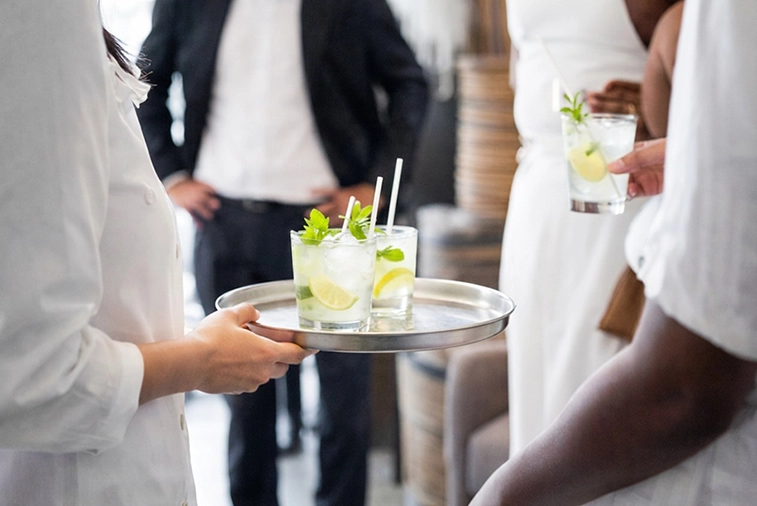 Serveuse présentant un plateau de cocktails lors d'une réception événementielle