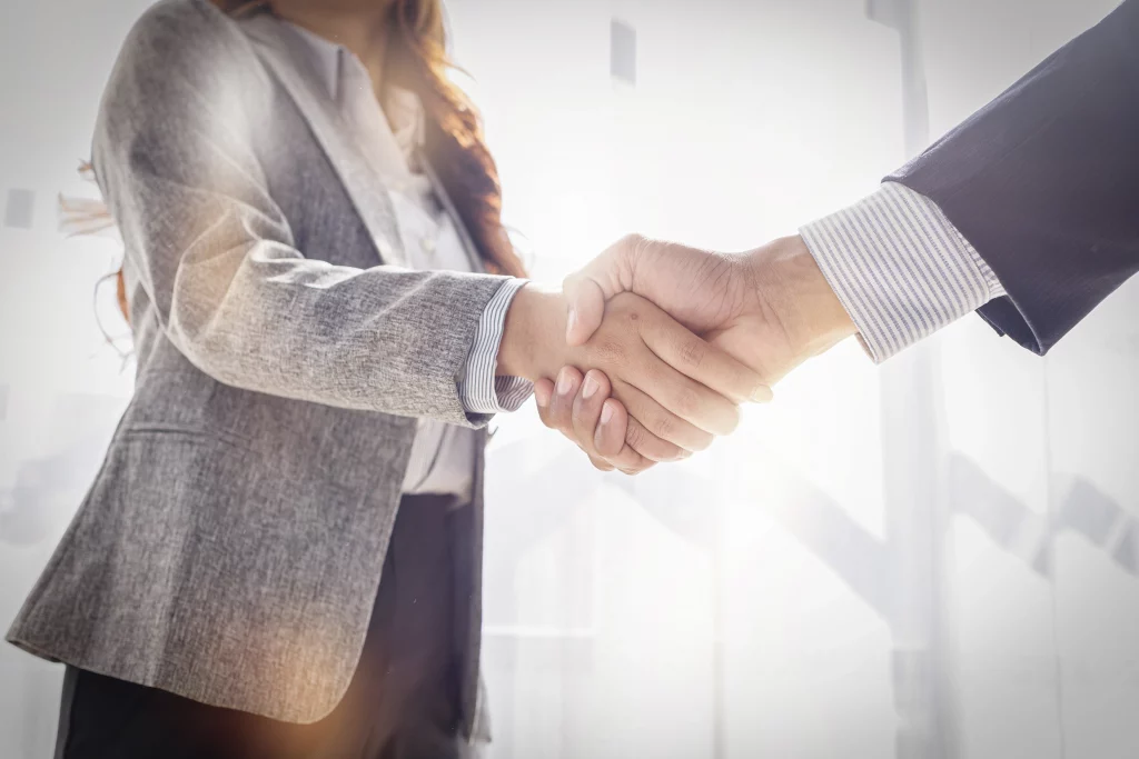 Poignée de main professionnelle entre deux personnes dans un bureau lumineux